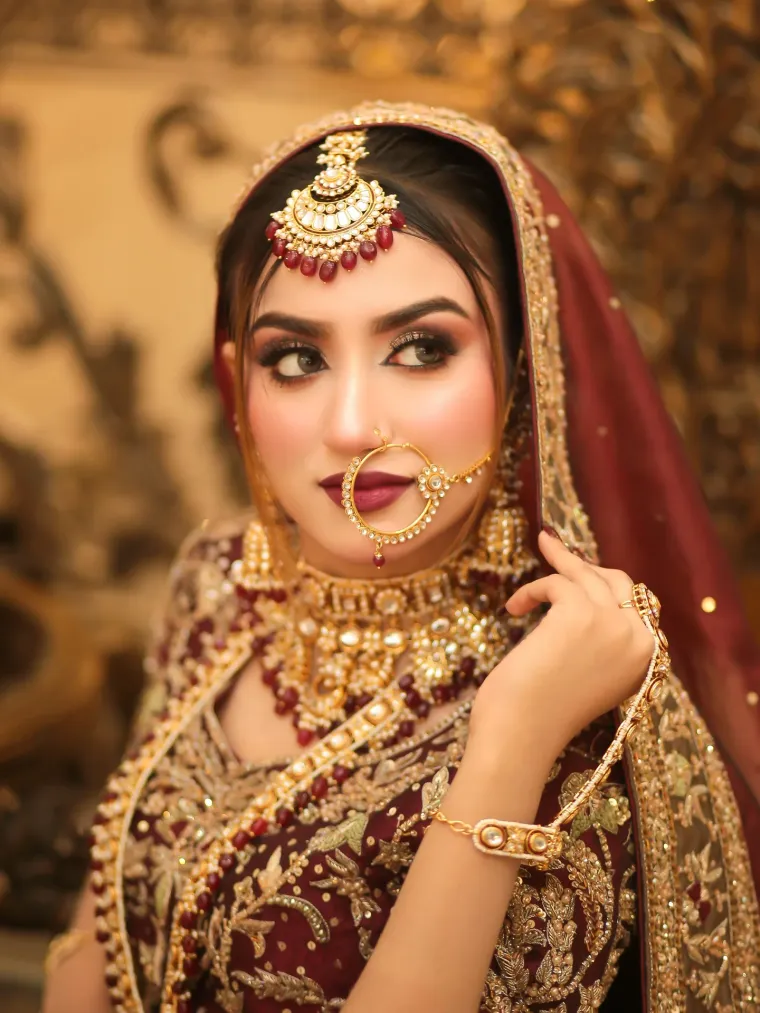 Blush Bar bride in a maroon lehenga with traditional gold jewellery and soft glam makeup