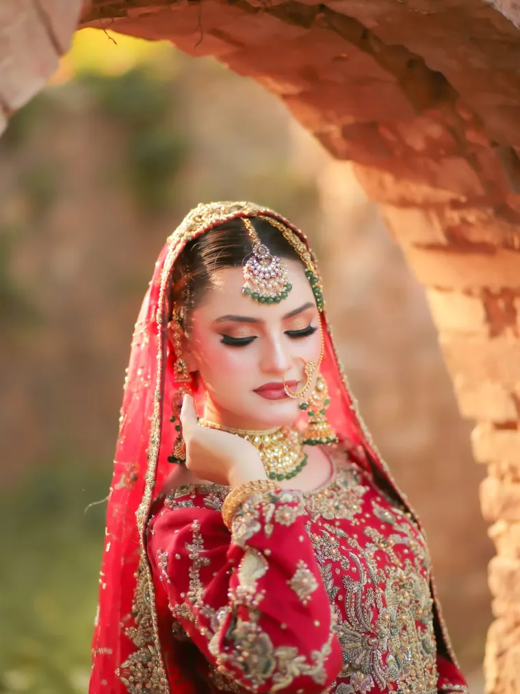 Bride in red and gold photographed in a stone archway